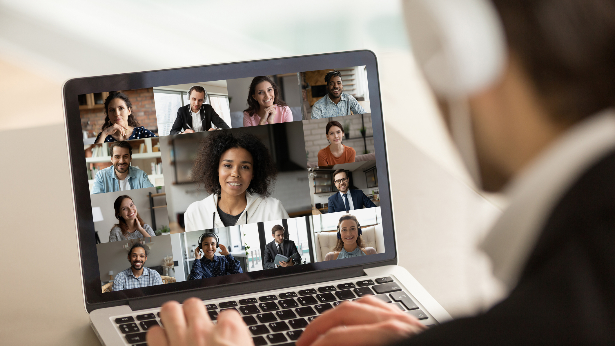 Young businessman holding working video call with diverse colleagues.